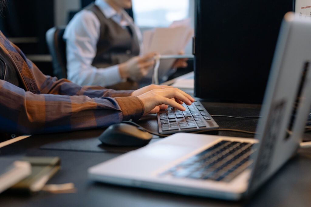 Close-up of office workers engaged in a tech project at a modern workplace.